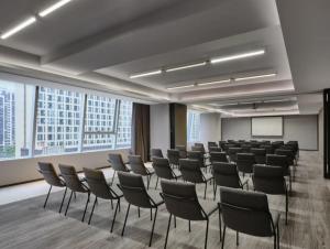 een kamer met rijen stoelen in een kamer met ramen bij Ningbo Wanda Moments Hotel in Ningbo