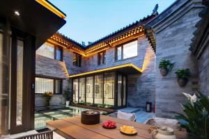 a house with a patio with a wooden table at 泊云小筑民宿 in Datong