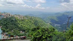 a view of a mountain with trees and a road at Himalayan 5 Elements Healing & Ayurveda in Narendranagar