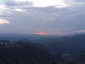 a view of a city from the top of a mountain at Himalayan 5 Elements Healing & Ayurveda in Narendranagar