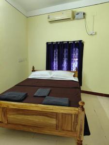 a bedroom with a large wooden bed with a window at Villa de valentin in Puducherry +47 photos