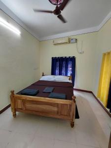 a bed in a room with a ceiling fan at Villa de valentin in Puducherry