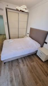 a bedroom with a large white bed with a ceiling at Kings Apartments in Tiberias