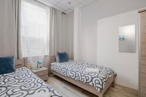 a bedroom with two beds and a window at Hostel Gdynia - Pokoje 2-osobowe na wyłączność in Gdynia