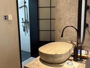 een badkamer met een stenen wastafel en een douche bij Not just Tea Space in Quanzhou