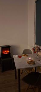 a living room with a table with two glasses of wine and a fireplace at Apartament Sosnowiec - Kazimierz Górniczy in Sosnowiec