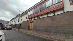 a building with a brick wall next to a street at Maruri Valentino apartment in Cusco