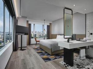een hotelkamer met een bed, een wastafel en een spiegel bij Ningbo Wanda Moments Hotel in Ningbo +31 foto's