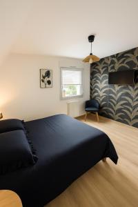 a bedroom with a black bed and a window at Proche Europa-Park & Marchés de Noël - 6 pers in Rhinau +12 photos