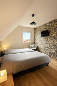a bedroom with a large bed and a stone wall at Proche Europa-Park & Marchés de Noël - 6 pers in Rhinau