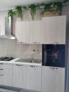 a kitchen with white cabinets and a sink and a stove at Nexus 2, Recale, Campania in Recale +4 photos