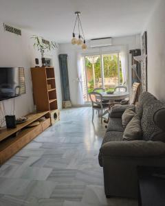 una sala de estar con un sofá y una mesa en Casa Micho, en Tomares