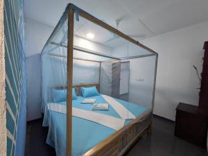 a bed with a glass canopy in a room at Manha Blue Villa Arugambay in Arugam Bay
