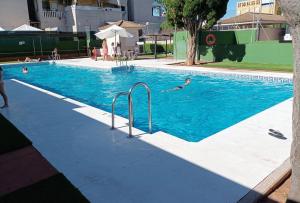 a group of people swimming in a swimming pool at Casa Micho in Tomares