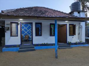 a small house with a blue pillar in front of it at Manha Blue Villa Arugambay in Arugam Bay
