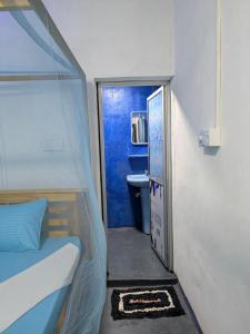 a small room with a bed and a bathroom at Manha Blue Villa Arugambay in Arugam Bay