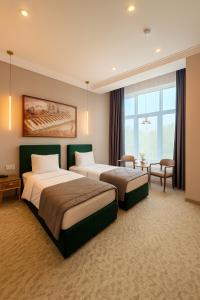 a hotel room with two beds in a room at Maestro Address Baku Hotel in Baku