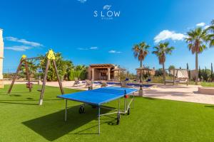 a playground with a blue table and a swing at Villa Es Contes by Slow Villas in Santanyi +27 photos