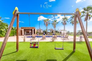 a swing set in a yard with a playground at Villa Es Contes by Slow Villas in Santanyi