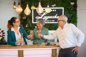 three people standing at a bar with glasses of wine at La Loggia superbe appartement in Pierry