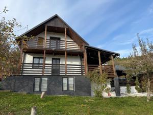 a large house with a gambrel roof at Cabana cu Livada in Mintiu Gherlii