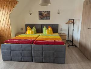 a bedroom with a large bed with yellow and orange pillows at Pension Sommerfrische in Nebra