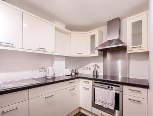 a kitchen with white cabinets and a stove top oven at Central 2BR flat - free parking - fast Wi-Fi in Bristol