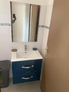 a bathroom with a sink and a mirror at Hébergement Maison -Les Abymes in Les Abymes +3 photos