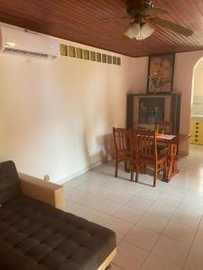 a living room with a couch and a table and chairs at Hébergement Maison -Les Abymes in Les Abymes