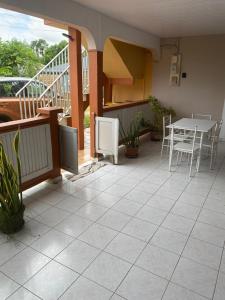 a patio with a table and chairs on a balcony at Hébergement Maison -Les Abymes in Les Abymes