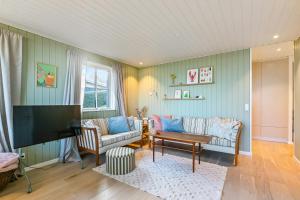 ein Wohnzimmer mit zwei Sofas und einem Flachbildfernseher in der Unterkunft Holiday Home With Sea View Near Hesselager in Hesselager