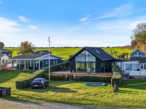 ein Haus mit einem im Hof geparkten Auto in der Unterkunft Holiday Home With Sea View Near Hesselager in Hesselager