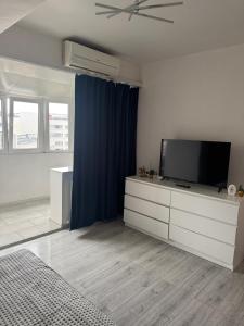 a living room with a tv and a blue curtain at Garsoniera centru in Craiova