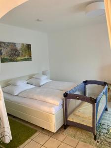 a bedroom with a white bed with a painting on the wall at 2 Zimmer Ferienwohnung mit Terrasse fußläufig zu S-Bahn nach München und See in Wörthsee
