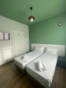 a bedroom with two beds with white sheets and pillows at Foresteria Alcatraz in Arluno