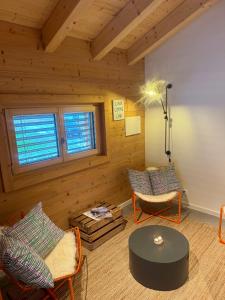 sala de estar con paredes de madera, mesa y sillas en Ski in out Swiss Alps Chalet Charelle by Jolidi, en Nendaz