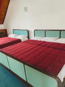 a bed with a red blanket on top of it at The Niwasa Resident in Nuwara Eliya