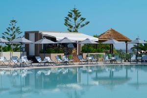 a swimming pool with chairs and umbrellas at Iberostar Waves Creta Panorama & Mare in Panormos Rethymno