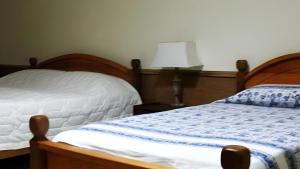 a bedroom with a bed and a lamp on a table at The Niwasa Resident in Nuwara Eliya