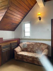 a living room with a couch and a window at The Niwasa Resident in Nuwara Eliya +1 photo