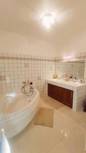 een witte badkamer met een bad en een wastafel bij Dépendance cocooning bon standing Ampuis in Ampuis