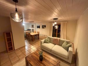 un soggiorno con un divano e un tavolo di Gemütliche Ferienwohnung am Kochelsee a Schlehdorf