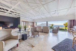ein Wohnzimmer mit Sofas und einem Tisch und Stühlen in der Unterkunft Luxury Coastal Living with Sea and Mountain View in Big Bay