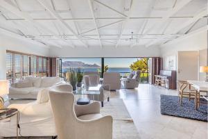 ein Wohnzimmer mit weißen Möbeln und Blick auf das Meer in der Unterkunft Luxury Coastal Living with Sea and Mountain View in Big Bay