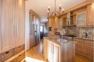 eine große Küche mit Holzschränken und einem Waschbecken in der Unterkunft Luxury Coastal Living with Sea and Mountain View in Big Bay + 29 Fotos