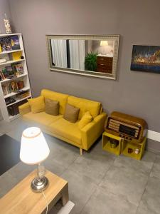 ルッカにあるPiccola Dimora B&Bのリビングルーム(黄色のソファ、鏡付)