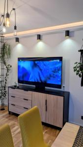 a living room with a large flat screen tv on a entertainment center at Zajazd u George'a in Ziębice