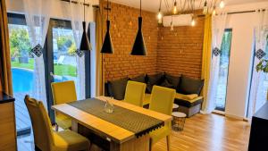 a dining room with a table and yellow chairs at Zajazd u George'a in Ziębice