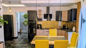 a kitchen with a table and yellow chairs at Zajazd u George'a in Ziębice +108 photos