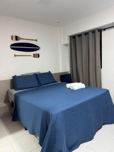 a bedroom with a blue bed with blue pillows at Makia Beach experience 107 D Premium in Ipojuca